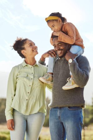 Parents, kids and happy family in park, garden and sunshine field outdoors for bonding, love and quality time together. Mom, dad and girl child of black family having fun, relax and care in nature